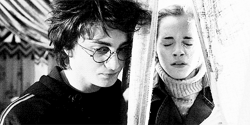 O gif mostra Daniel Radcliffe caracterizado como Harry Potter e Emma Watson caracterizada como Hermione Granger. Ele estão separados por uma cortina, mas Hermione ultrapassa a barreira para abraçar Harry. 
