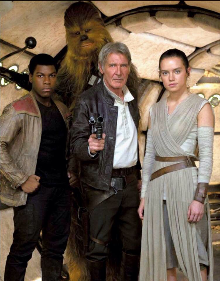 Imagem de Finn, Han Solo, Rey e Chewbacca. Han Solo está no meio e aponta uma arma para a câmera. À sua esquerda, está Finn, com as mãos na cintura. Entre os dois mas atrás, está Chewbacca, segurando sua arma. À direita de Han Solo, está Rey. Todos posam para a foto e encaram a câmera diretamente.