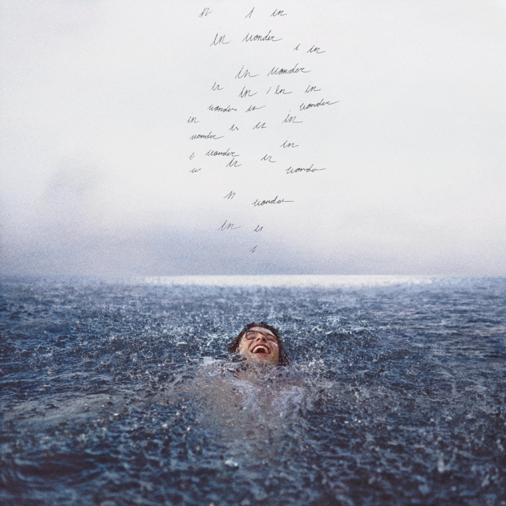 Capa do disco Wonder. Shawn Mendes está nadando e sorrindo, acima dele vemos escritos ilegíveis