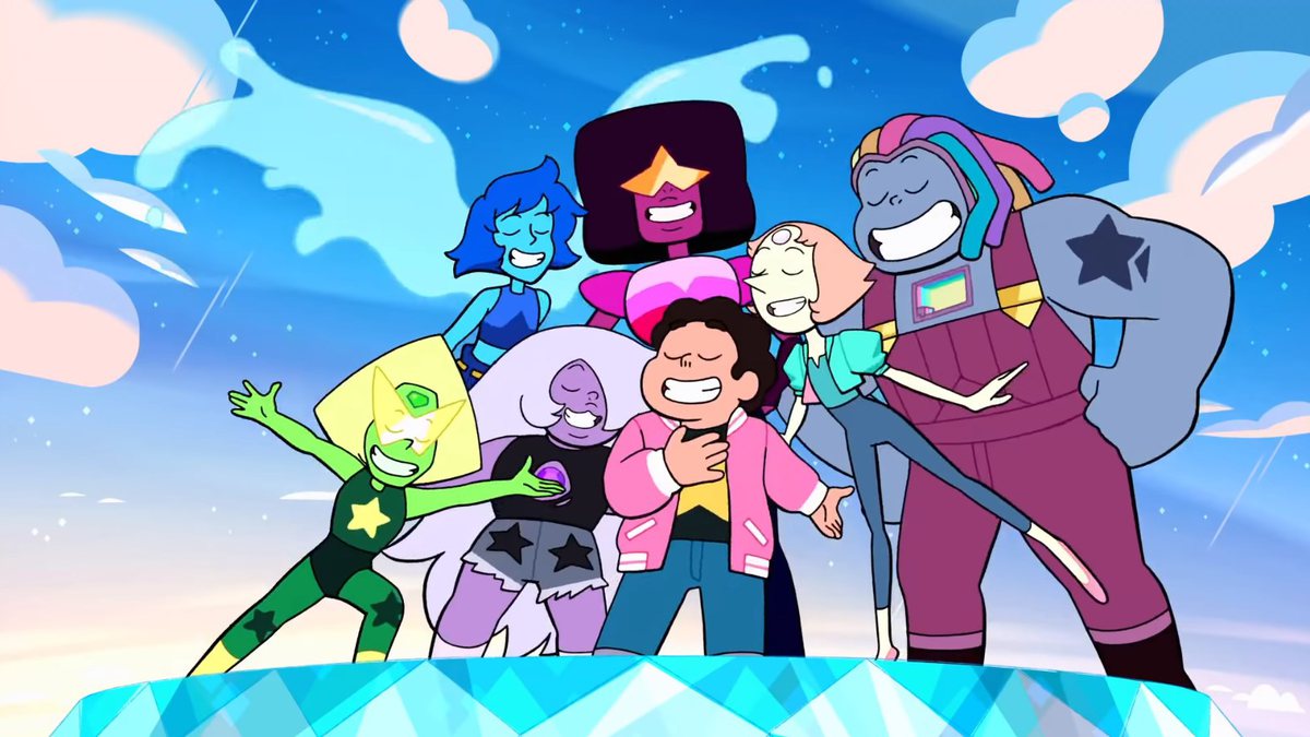 Cena do desenho Steven Universe. A imagem mostra 7 personagens da série que estão de frente, e a câmera está um pouco para baixo. Elas estão de olhos fechados e sorrindo. Ao fundo, há um céu azul com nuvens. As personagens estão em cima de uma plataforma azul.