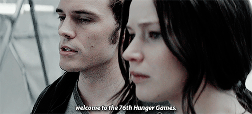 O gif mostra Katniss e Finnick. Ela tem os cabelos presos em um rabo de cavalo baixo e ele está à sua direita. Apenas os rostos dos dois aparecem. Em baixo está a legenda “welcome to the 76th Hunger Games”.