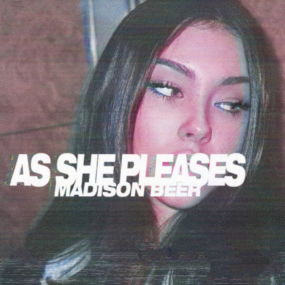 Capa do ep As She Pleases. Uma foto com efeito rosa do rosto de Madison, mulher branca de cabelos pretos, olhando para o lado direito. No meio, está escrito “AS SHE PLEASES / MADISON BEER” em branco.