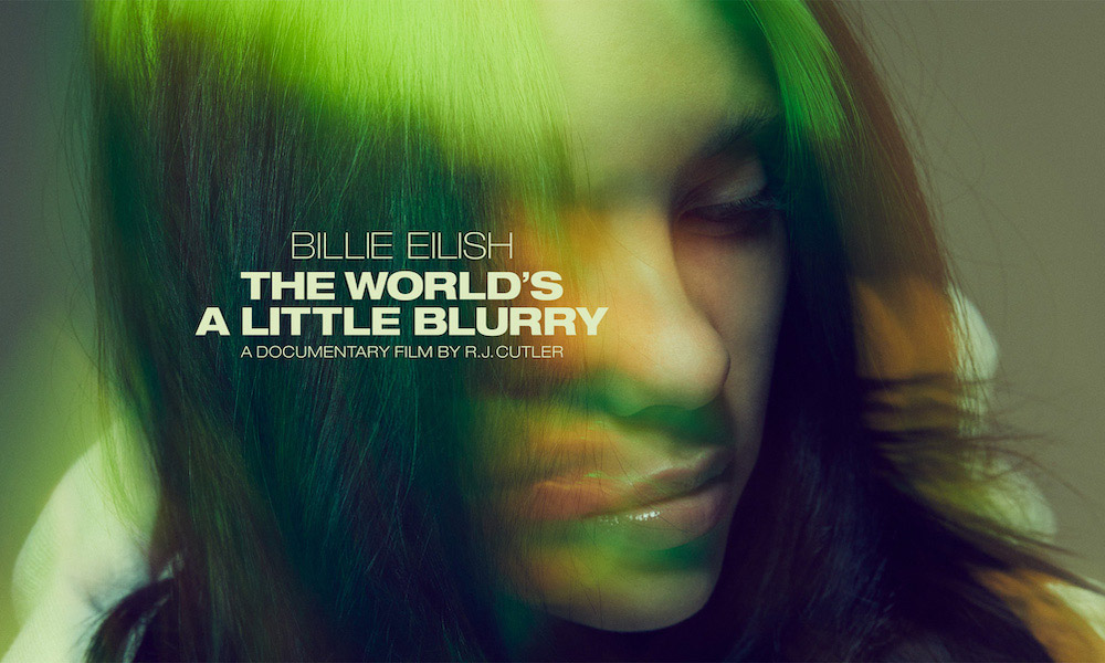 Capa de divulgação do documentário 'The World's a Little Blurry'. O rosto de Billie Eilish está virado para o lado, e seus olhos estão quase fechados, em uma expressão séria. Seu cabelo é preto com raízes verdes.