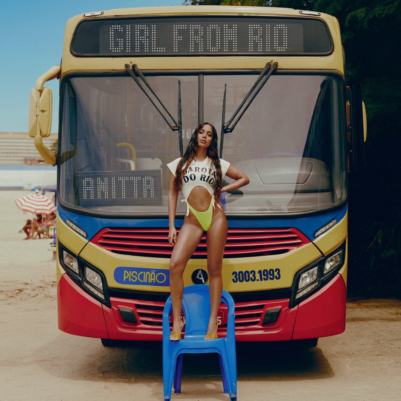 Capa do single Girl From Rio de Anitta. A cantora está em cima de uma cadeira azul de praia, vestindo um maiô verde fluorescente e um top branco escrito GAROTA DO RIO. Ela apoia o braço esquerdo na cintura. Atrás dela, podemos ver a frente de um ônibus amarelo, azul e vermelho, com o letreiro digital escrito GIRL FROM RIO. No letreiro do vidro, está escrito ANITTA. A cantora e o ônibus estão na areia do Piscinão de Ramos, no Rio de Janeiro. 