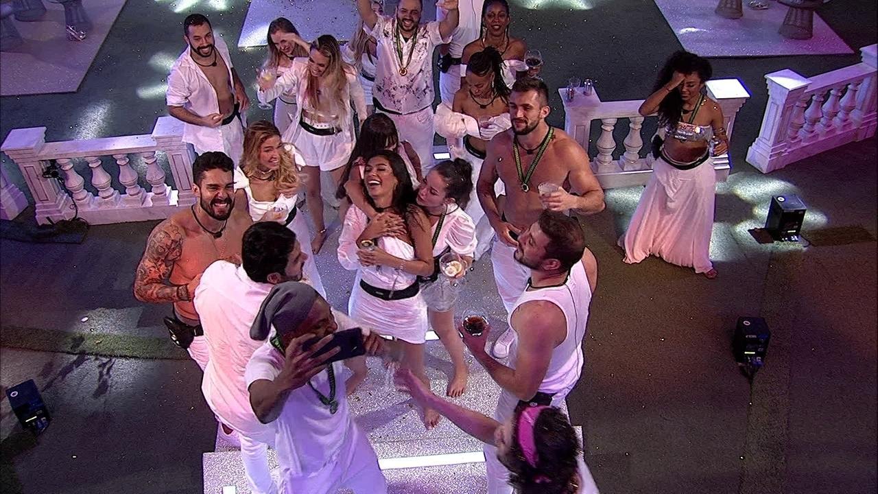 Cena do Big Brother Brasil 21. Vários participantes estão se divertindo na Festa Réveillon, vestidos de branco.