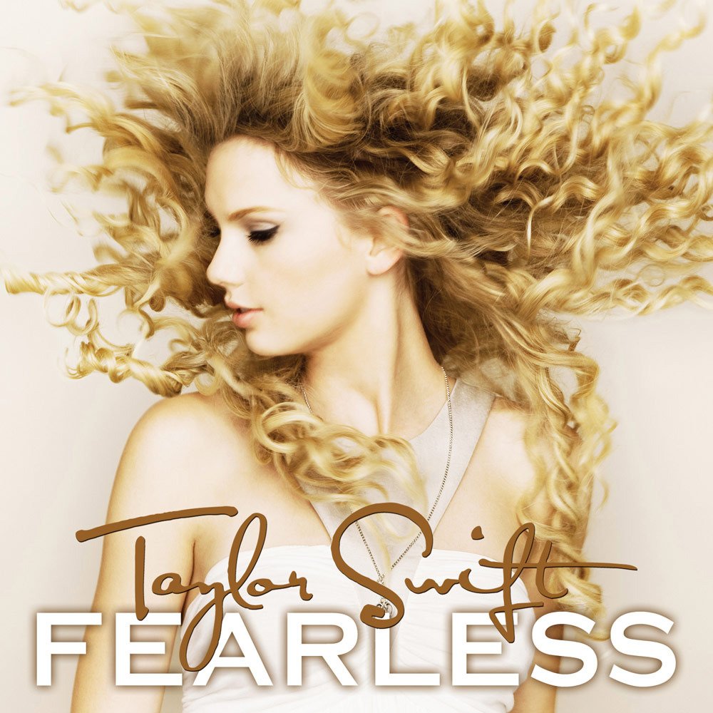 Capa do álbum Fearless, de Taylor Swift. A capa é composta por uma de um fundo branco com Taylor. Ela, uma mulher branca, está ao meio da imagem, com seu cabelo loiro e cacheado jogado para o alto dando a impressão que Taylor estava pulando no momento da foto. Na parte inferior da capa do álbum, ao meio, está escrito o nome de Taylor Swift em letra de mão num tom de marrom claro, e embaixo deste está o nome do álbum, Fearless, em caixa alta e branco com contorno e sombra marrom.