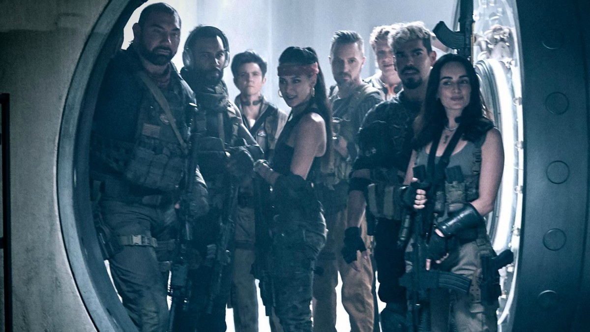 Foto de divulgação de Army of the Dead. Na imagem, ao centro, vemos oito dos personagens do filme armados em frente a uma porta de cofre aberta.