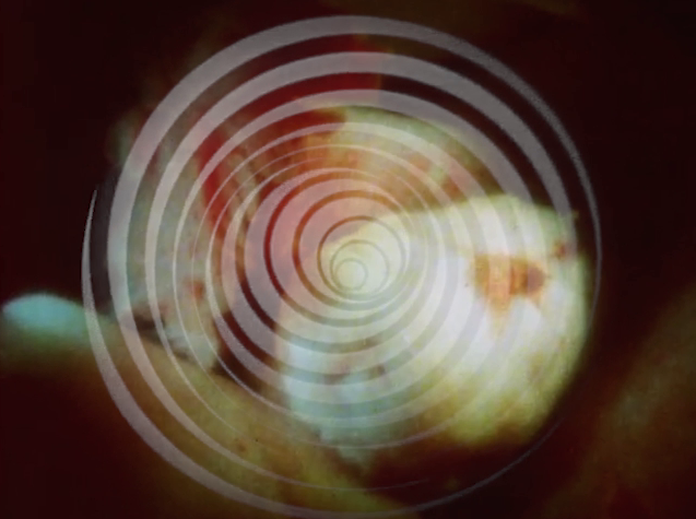 Cena de Invasão exibe uma espiral branca com uma imagem abstrata e borrada ao fundo.