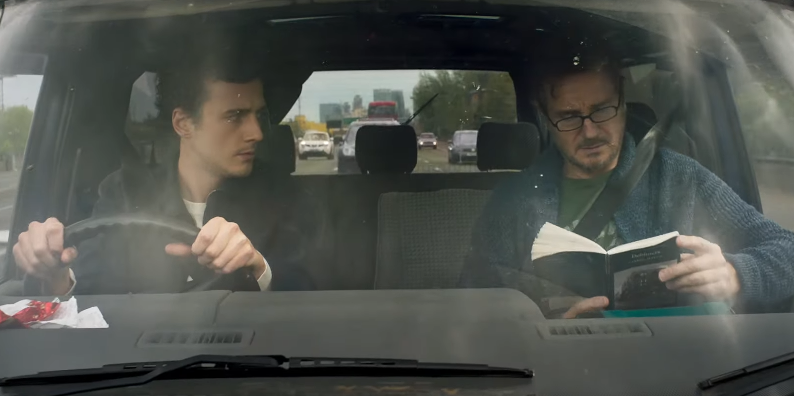 Cena do filme Made in Italy. A cena mostra Liam e seu filho Micheál no carro, eles sao brancos e está de dia.