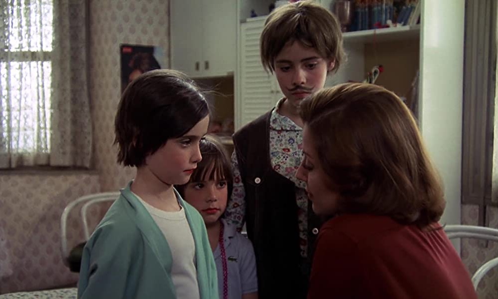 Cena do filme Cría Cuervos que mostra Ana, Maite e Irene ouvindo os conselhos da Tia Paulina. O fundo da imagem é o quarto das meninas.