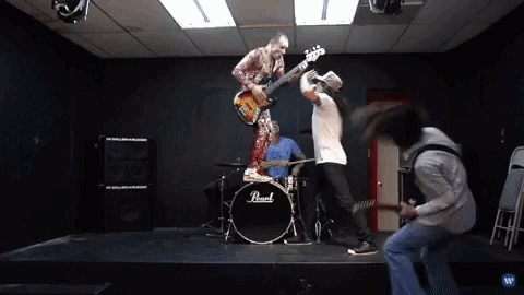 Gif de integrantes da banda Red Hot Chili Peppers em um estúdio de música preto. Todos estão pulando e se divertindo com brincadeiras