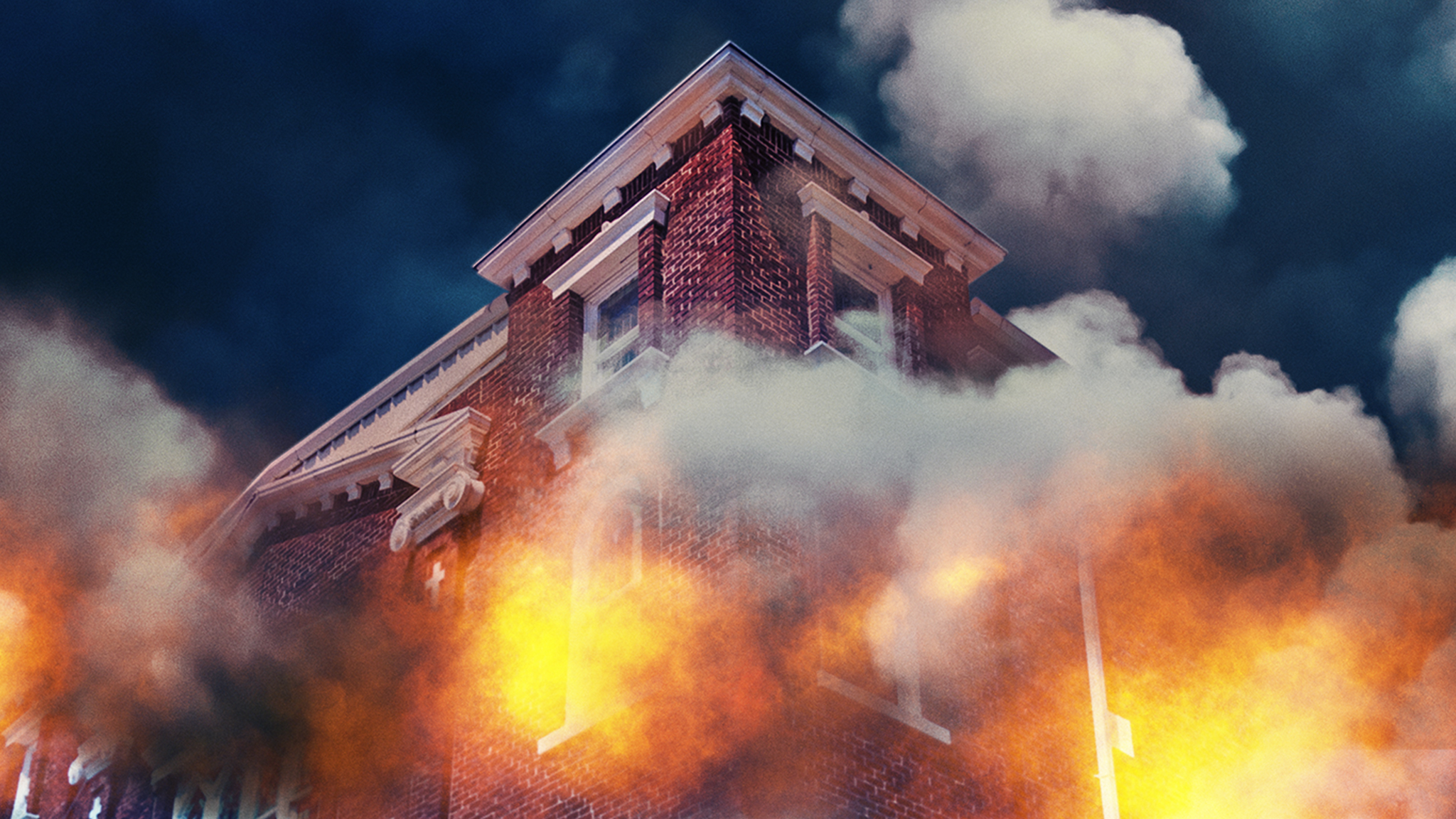  Cena do documentário Tulsa Burning: The 1921 Race Massacre. A imagem mostra a esquina de um prédio de tijolos vermelhos em chamas, visto de cima para baixo. O céu é azul escuro e é tomado por uma fumaça cinza, que surge do fogo que sai de dentro das janelas brancas do prédio.