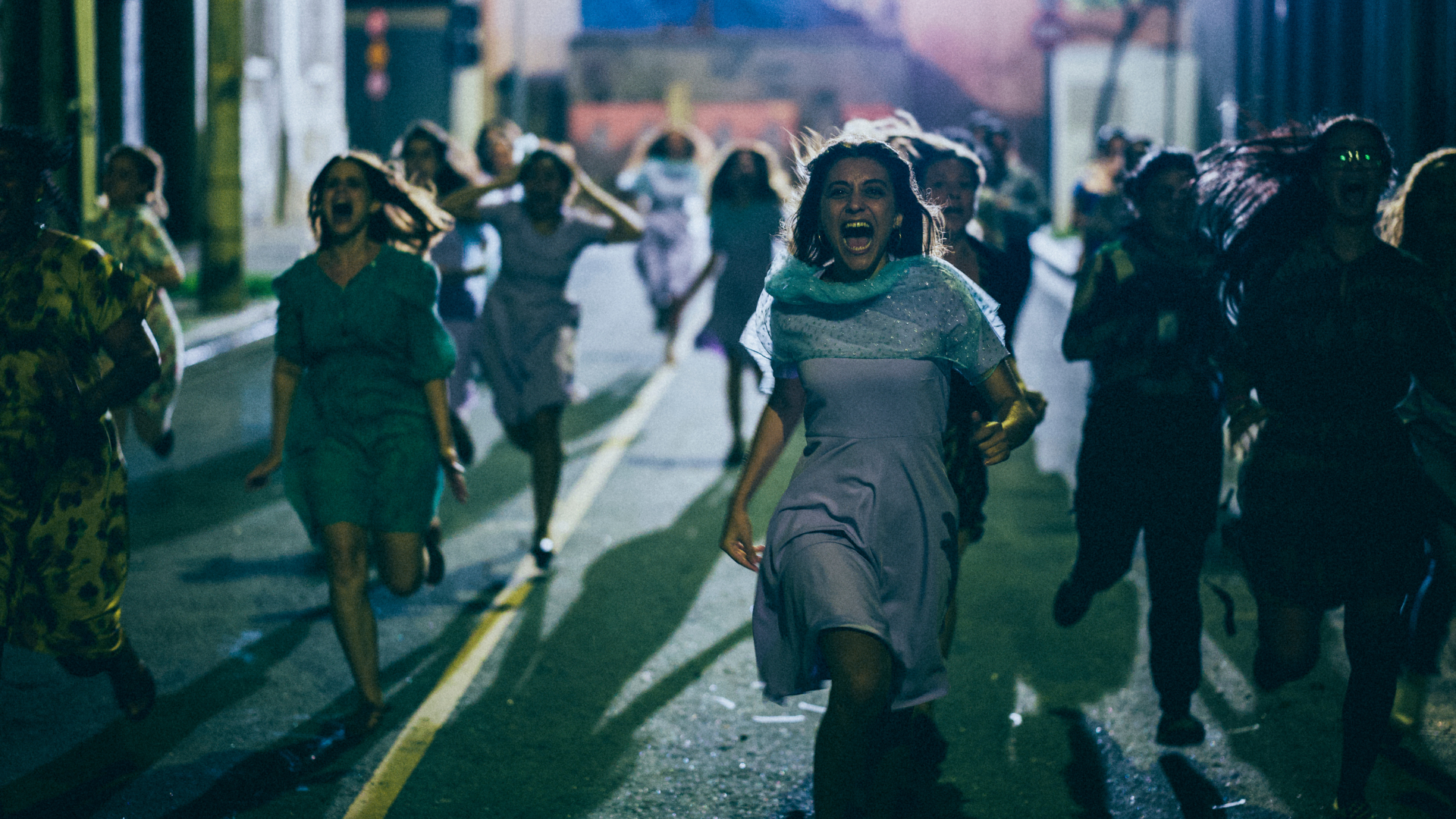 Cena do filme Medusa. A imagem mostra um grupo de mulheres correndo e gritando na rua, a noite.