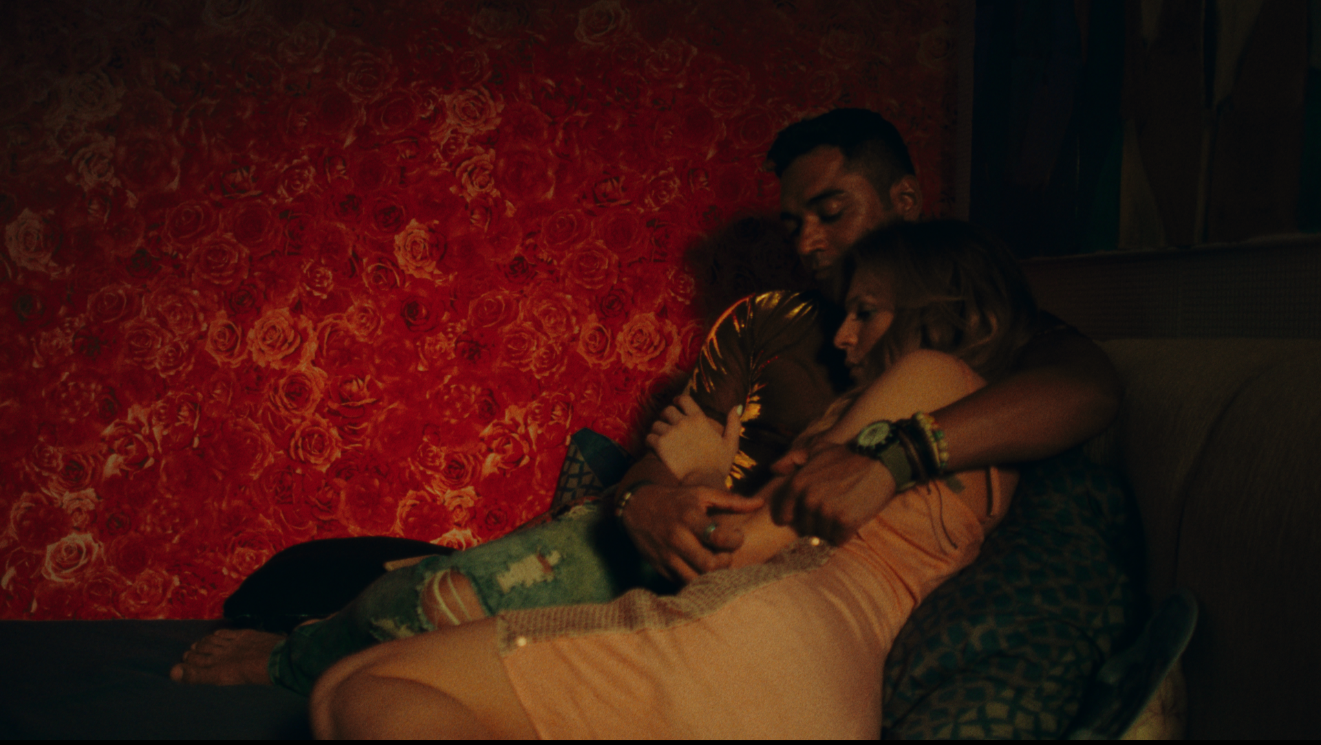 Cena do filme Deserto Particular, mostra um homem e uma mulher deitados em um sofá, abraçados.