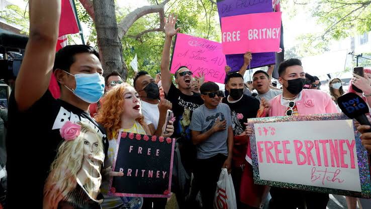 A imagem exibe um grupo de jovens segurando cartazes em um protesto pela liberdade tutelar da cantora Britney Spears.