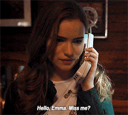 Cena da série Scream. No gif, vemos a protagonista Emma, uma mulher branca, de cabelos loiros lisos e longos, aparentando ter cerca de 18 anos, segurando um telefone branco próximo à orelha. Na legenda do gif, vemos as palavra “Hello, Emma. Miss me?”.