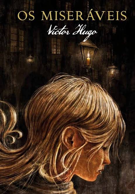 Capa do livro Os miseráveis mostra o perfil de uma menina branca e loira de expressão triste. Ao fundo da cena há alguns lampiões e no topo da foto está escrito Os Miseráveis em dourado e Victor Hugo em baixo em branco.