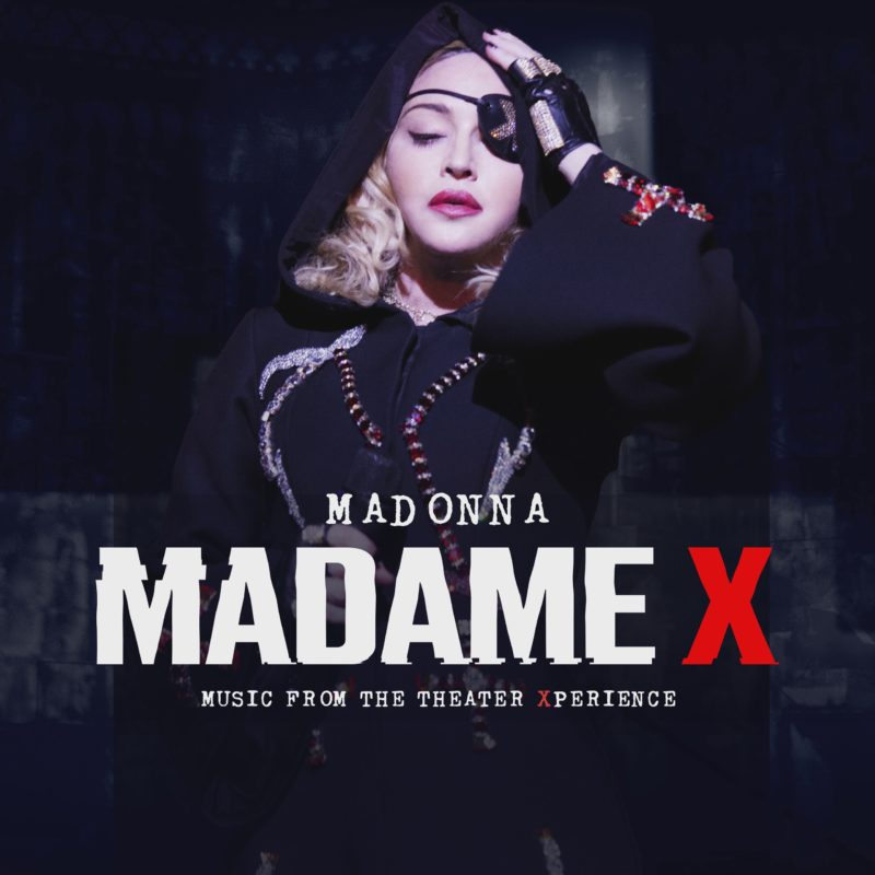 Capa do álbum Madame X - Music From The Theater Experience (Live). Fotografia quadrada, com fundo azul-escuro. A cantora Madonna ocupa quase toda a imagem. Ela é uma mulher branca, loira, de batom, tapa olho, vestindo uma roupa preta, de capuz, com alguns detalhes em pedraria, e segurando um microfone com a mão direita. Na parte inferior da foto, mais ou menos sobre o abdômen de Madonna, lemos Madonna Madame X Music From The Theater Xperience em letras brancas, com exceção das duas letras X, que são vermelhas. 