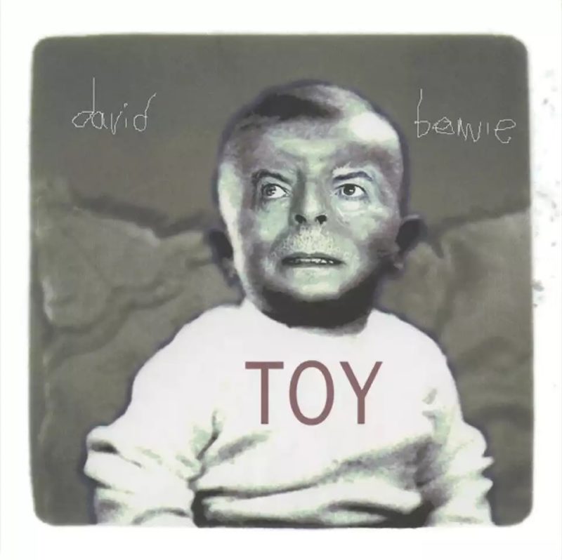 Capa do álbum Toy. A imagem em tons de cinza mostra o corpo de um bebê vestido com um agasalho branco, com os olhos, nariz e boca de David Bowie editados sobre seu rosto. A cabeça se encontra entre as palavras “david” e “bowie”, registradas com uma escrita torta, como de uma criança. Sobre o peito, se encontra a palavra “TOY”.