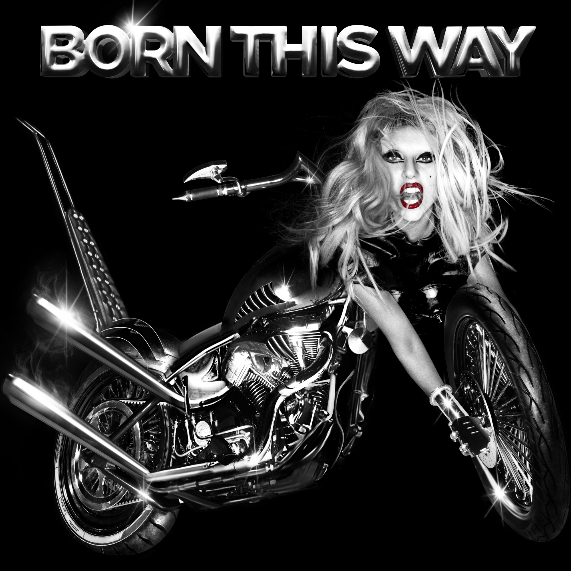 Capa do disco Born This Way, de Lady Gaga. A imagem está em preto e branco, apenas com o batom de Gaga em vermelho. Na parte superior, foi adicionado o texto “BORN THIS WAY”. Abaixo, foi adicionada uma montagem que mostra a cantora sendo metade humana, metade motocicleta. De seu corpo, a cabeça está onde deveria estar o guidão da moto, e os braços seguram a roda da frente.