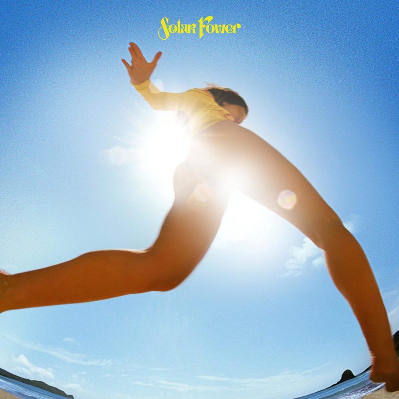 Capa do cd Solar Power mostra Lorde correndo pela praia, com a foto sendo tirada por um ângulo de baixo para cima.