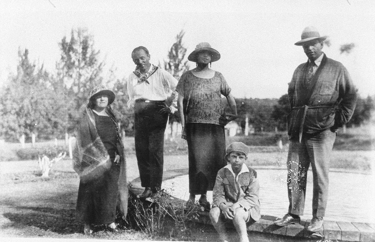Fotografia em preto e branco de Tarsila do Amaral, Oswald de Andrade, Mário de Andrade em viagem. Eles estão todos de pé, na frente de um descampado.