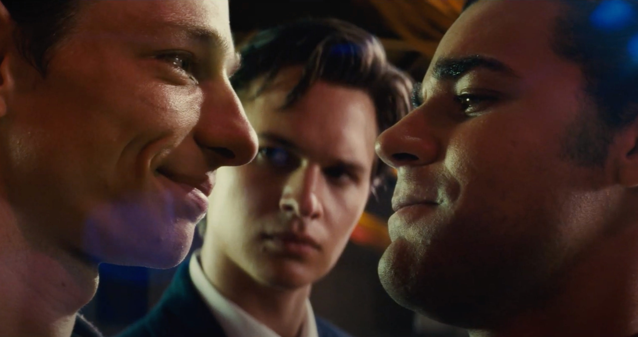 Cena do filme Amor, Sublime Amor. A cena mostra um close-up dos rostos de Mike Faist e David Alvarez, e no meio deles está o ator Ansel Elgort. 