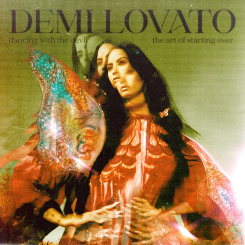 Capa do álbum 'Dancing With The Devil... The Art of Starting Over', de Demi Lovato. Nela, Demi Lovato está com as mãos em sua cintura, e ela usa um vestido kimono vermelho. A imagem é holográfica, e o corpo de Demi se repete três vezes sobre a o fundo verde. Seus cabelos são longos, na altura de sua costela, e sob suas madeixas existem pequenas borboletas de acessório.