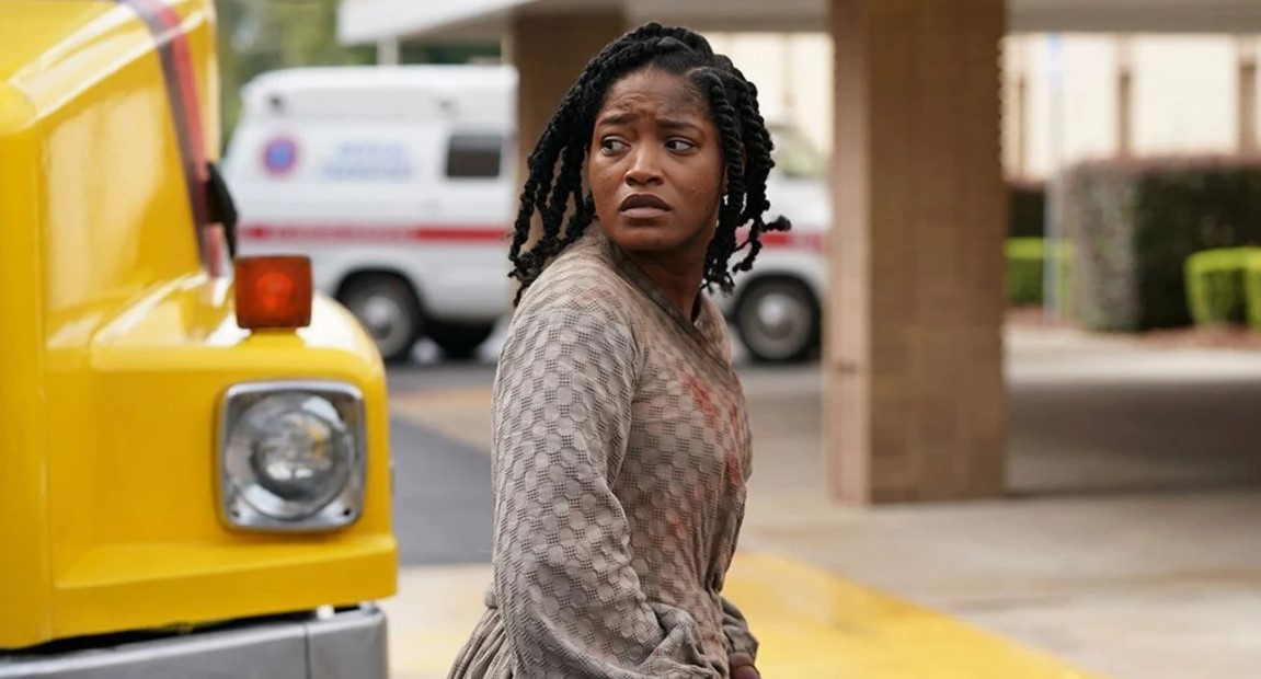 Cena do filme Alice, mostra uma mulher negra atravessando a rua com expressão de preocupação no rosto e olhando para trás.