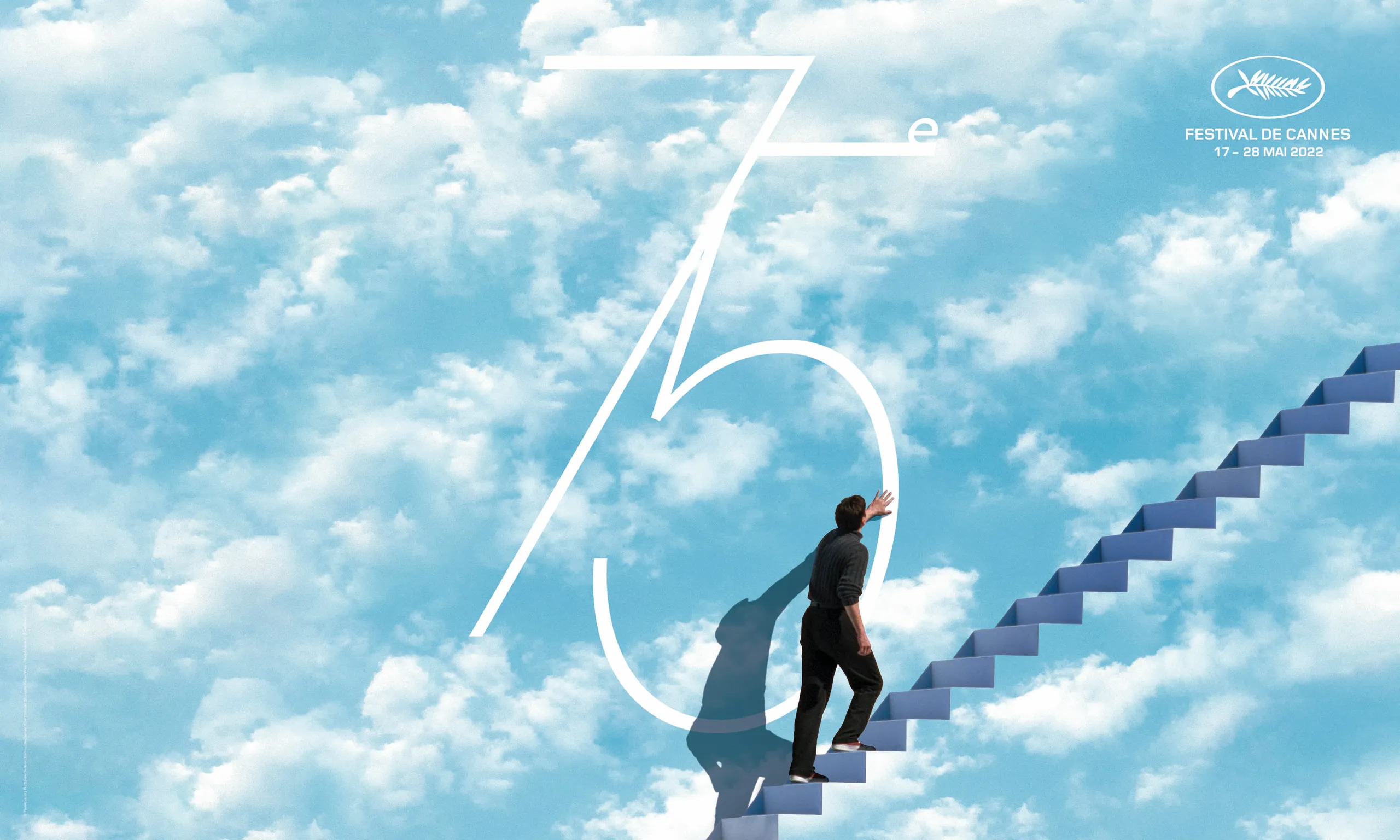 Banner do 75º Festival de Cannes. O pôster mostra uma cena do filme O Show de Truman, com um homem subindo escadas e tocando na parede, que tem o desenho de um céu azul com nuvens brancas. Nele, está o número 75 e o logo do Festival de Cannes.