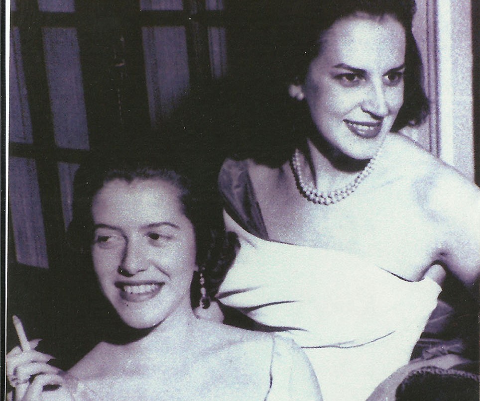 Fotografia de Hilda Hilst e Lygia Fagundes Telles em preto e branco. Hilst, à esquerda, segura um cigarro com a mão enquanto sorri olhando para o lado. Telles, à direita, sorri olhando para o lado oposto. As duas são mulheres brancas de cabelos escuros.