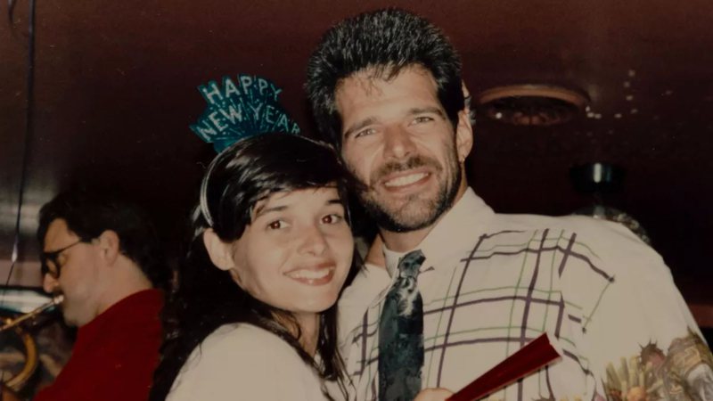 A foto retrata Daniella Perez e seu marido Raul Gazolla, ambos sorrindo, em uma festa de ano novo. A atriz está de blusa branca e com uma tiara na cabeça com Feliz Ano Novo escrito em inglês e ele com uma blusa listrada e uma gravata preta. 