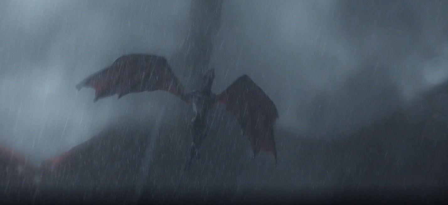 Cena de House of The Dragon. Nela vemos um dragão voando no céu enquanto chove à noite. Em cima dele, há a sobra de um dragão muito maior