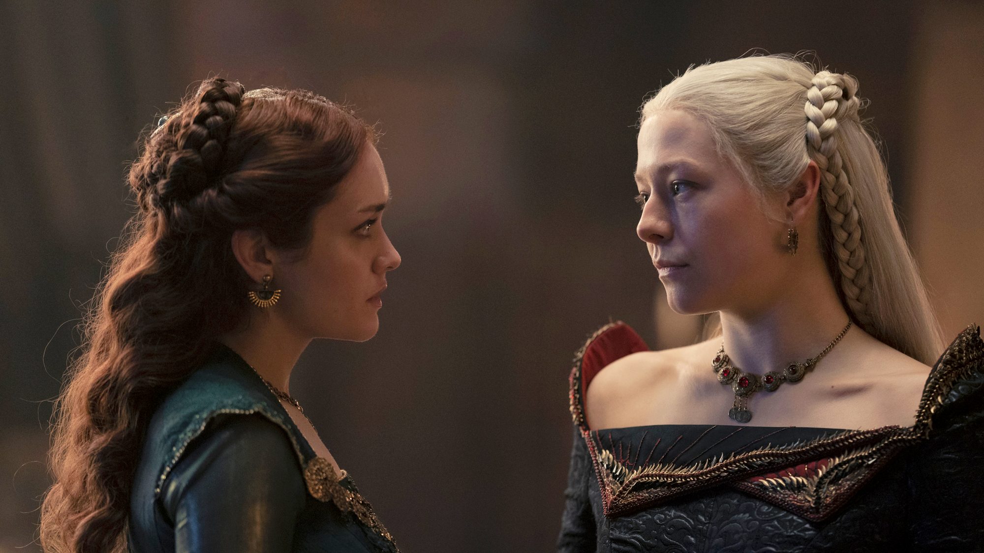 Cena da série em que Alicent Hightower, à esquerda, usando um vestido verde, encara Rhaenyra Targaryen, que veste um vestido preto com ornamentos vermelhos.