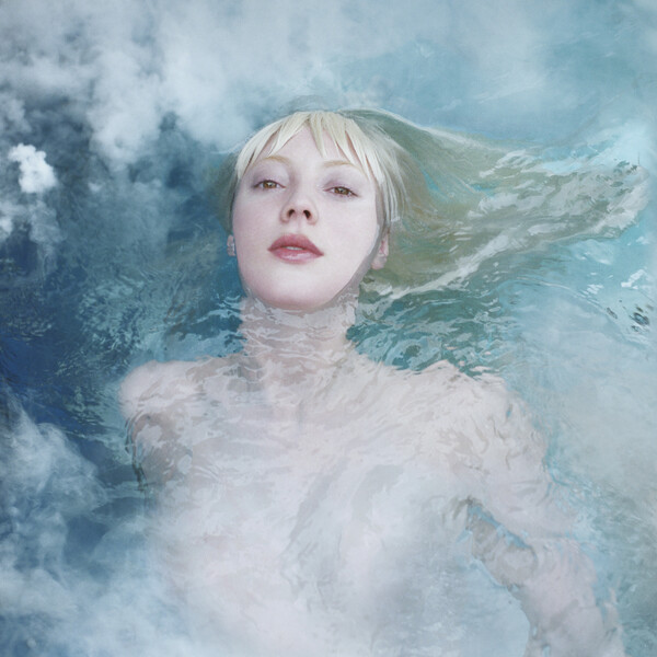 capa do álbum Clearing, a cantora Hayden Dunham está no meio da capa, com o corpo mergulhado em água e o rosto exposto.