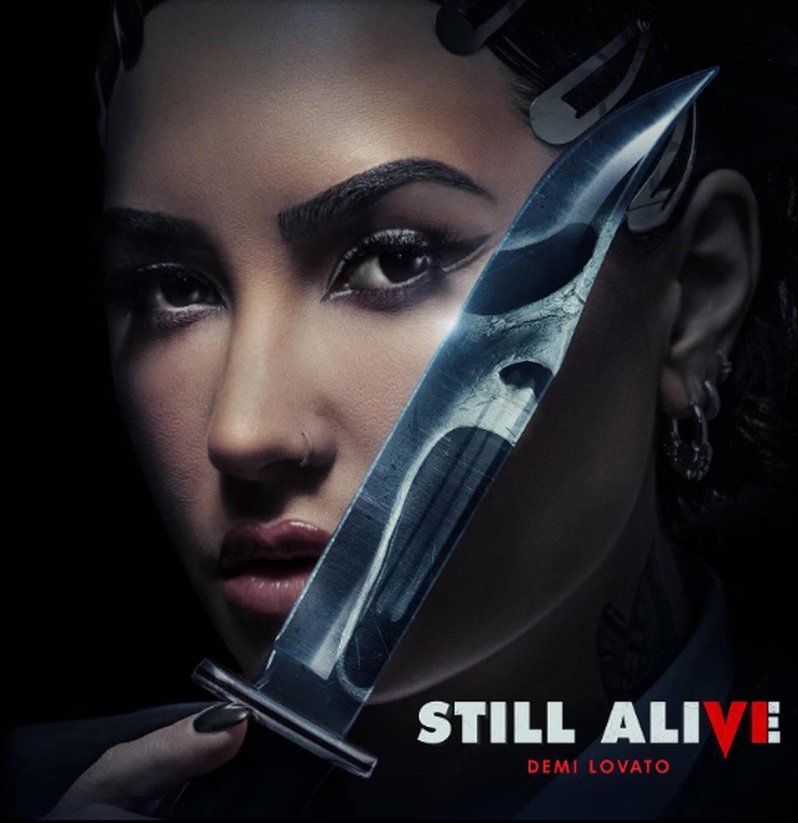 Foto da cantora Demi Lovato. Nela, ela está segurando uma faca e sua unha está pintada de preto.