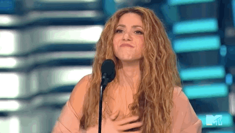 Imagem em movimento de Shakira, mulher branca, recebendo o prêmio Vanguard no palco do VMAs. A imagem mostra a artista agradecendo à plateia pelo troféu.