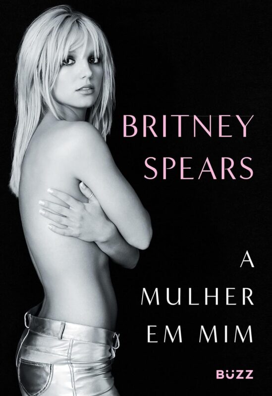 Capa do livro A mulher em mim de Britney Spears. A arte de capa é uma fotografia em preto e branco de Spears, uma mulher branca de cabelos claros e olhos escuros. Ela está posicionada no canto esquerdo da arte, olhando para a câmera de lado enquanto veste uma calça e encobre os seios. O fundo é preto e ao lado de Britney Spears está escrito seu nome em letras garrafais rosa seguido do título do livro em letras garrafais brancas “A MULHER EM MIM