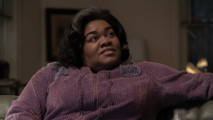 Cena do filme “Os Rejeitados”. A imagem mostra a personagem Mary Lamb sentada em um sofá. Mary é interpretada por ine Joy Randolph, que é uma mulher negra, de cabelos pretos. Ela usa um casaco de veludo roxo. 