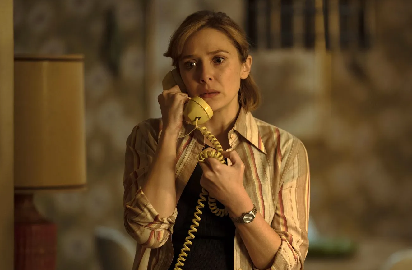 Candy Montgomery (Elizabeth Olsen) fala ao telefone, com uma expressão de preocupação e tristeza.