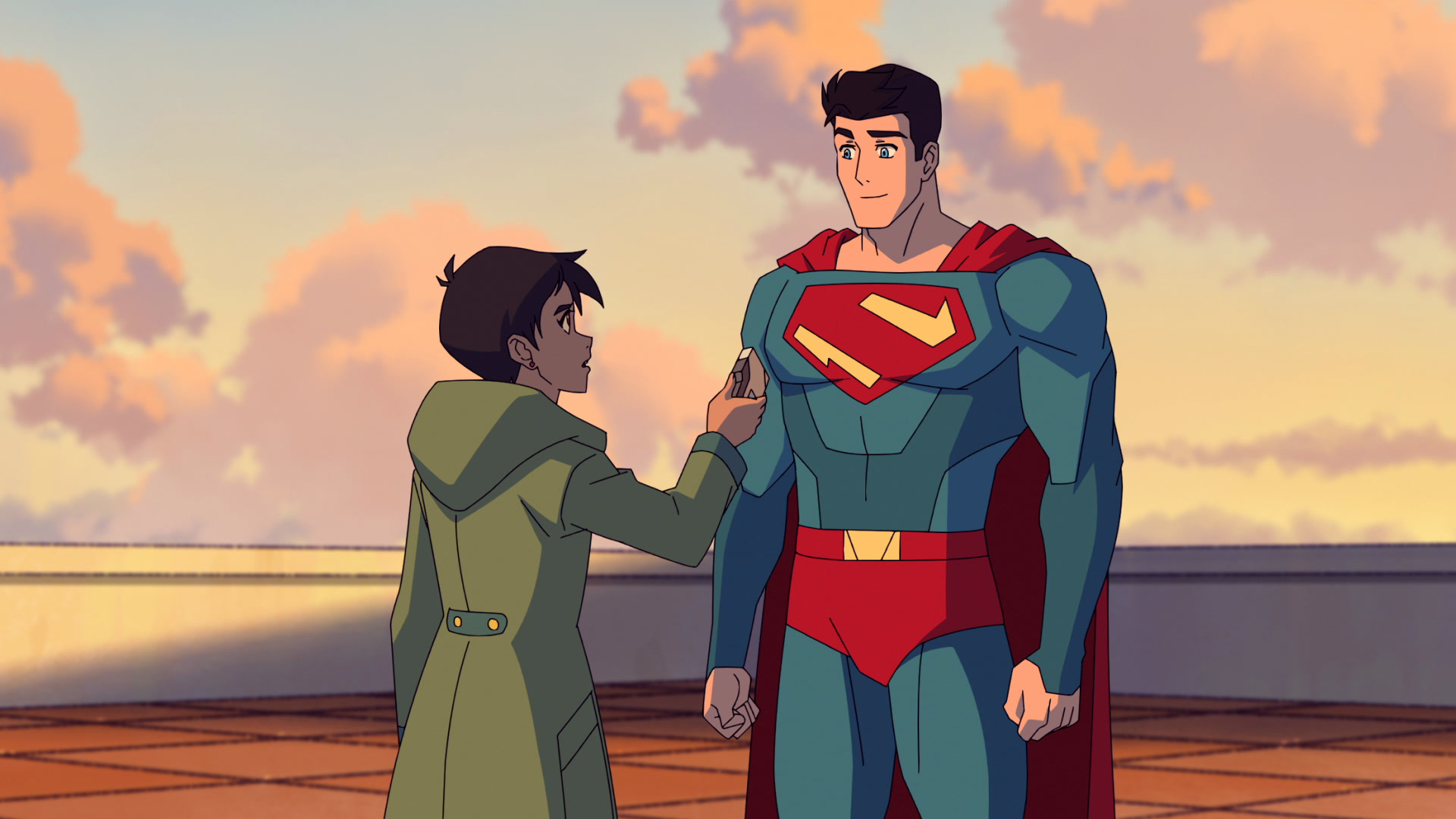 Cena da série Minhas Aventuras com o Superman. Na imagem do desenho animado, estão dois personagens, sendo um deles o Superman, um homem branco de olhos claros e cabelos escuros que veste um uniforme azul com detalhes em vermelho.