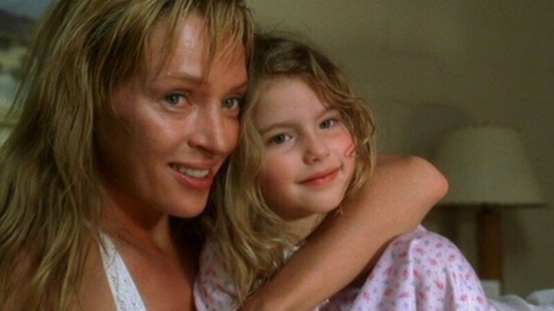 Cena do filme Kill Bill - Volume 2. Na imagem, Beatrix está abraçada com sua filha. Ambas são brancas e loiras e estão sorrindo.