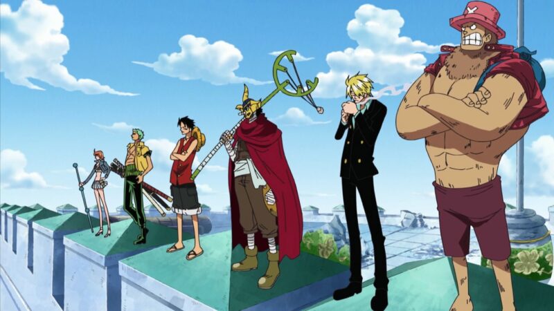 Cena do anime One Piece. Tem seis pessoas na imagem. Da esquerda para a direita está Nami, ela está de cabelo curto e veste um cropped preto com uma jaqueta jeans por cima e uma saia jeans. Em sua mão direita ela segura um bastão. Do seu lado está Zoro, ele veste uma camisa amarela aberta, uma faixa verde na cintura e uma calça verde, na sua cintura tem três espadas na bainha. Ao seu lado está Luffy, ele veste uma camisa vermelha, uma bermuda preta e chinelo, nas suas costas está pendurado seu chapéu de palha. Seguido dele está Usopp, ele veste um macacão marrom, uma faixa branca na cintura, botas marrons, uma capa vermelha e uma máscara amarela no rosto, na sua mão direita ele segura um estilingue gigante. Do seu lado está Sanji, ele veste um terno preto e uma camisa azul, ele está acendendo um cigarro. Na direita está Chopper, ele está mais alto e musculoso, ele veste uma jaqueta vermelha, um shorts vermelho e um chapéu rosa na cabeça, nas suas costas tem uma mochila azul. Todos estão enfileirados em cima de um prédio olhando para o horizonte, no fundo tem o céu.