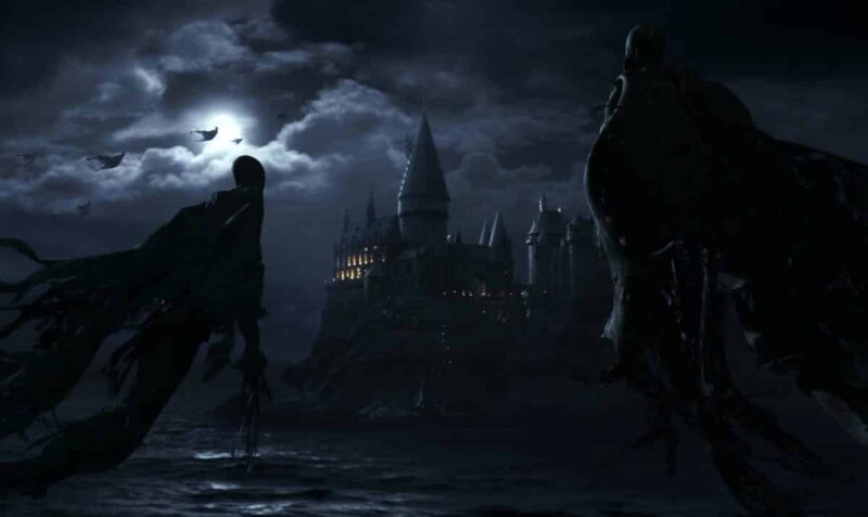 Está escuro porque está de noite. A lua na parte superior esquerda ilumina todo o resto da imagem. Os dementadores com suas capas pretas flutuam próximas a tela e em frente a lua mais ao fundo. No no centro e fundo da tela está Hogwarts