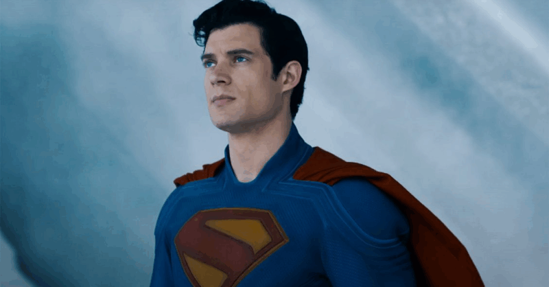 Cena de Superman. Centralizado na imagem está Superman. A imagem só mostra do seu peito para cima. Ele está todo trajado e seu uniforme está limpo. Seu rosto demonstra obstinação. 