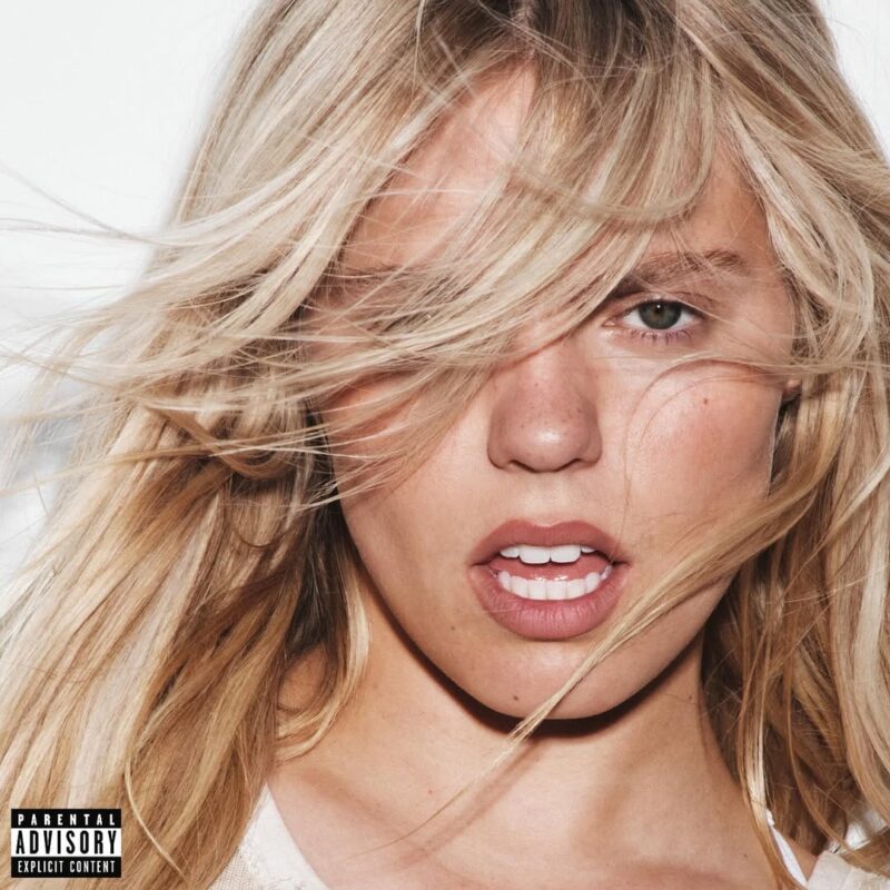 A capa do álbum Bite Me de Renee Rapp. A imagem é um close-up da cantora com seus longos cabelos loiros desarrumados, que cobrem parcialmente seu rosto. Ela tem uma expressão intensa e olha diretamente para a câmera com a boca levemente aberta.