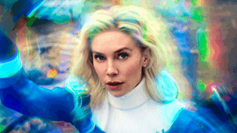 A imagem mostra Sue Storm, uma mulher loira de olhos azuis, envolta por um fundo abstrato com efeitos de luz e cores vibrantes, representando seu campo de força. Com expressão determinada, ela veste um traje azul e branco. O fundo é composto por um turbilhão de tons intensos que criam uma atmosfera dinâmica e energética, sugerindo ação/habilidades sobre-humanas. O estilo visual é moderno e experimental, com uso expressivo de luz e cor para enfatizar a força e o foco da personagem em um ambiente surreal.