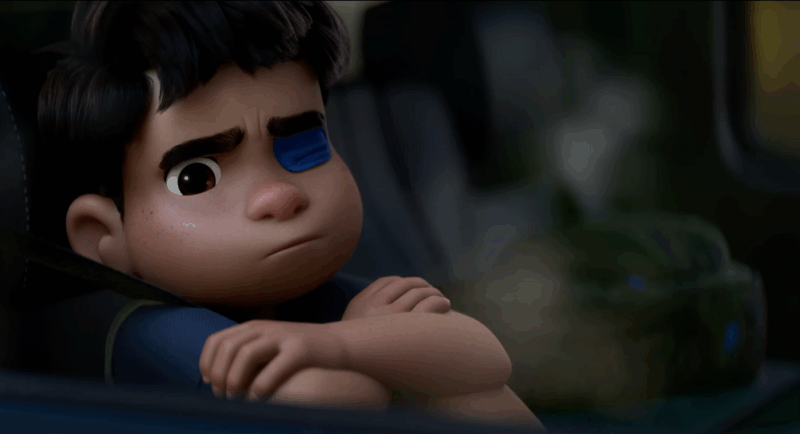 Cena do filme ElioNa imagem, Elio está sentado no banco do carro, com uma expressão de raiva. Sua cabeça está encostada na janela e seus braços estão cruzados sobre seu joelho. Ele veste uma camiseta azul escura e está com um tapa olho também azul no olho esquerdo. 