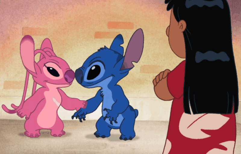  Cena de uma série de Lilo & Stitch mostrando Stitch, o alienígena azul, segurando as mãos de um outro personagem alienígena rosa, Angel. Os dois estão de frente um para o outro em um momento de conexão amigável. À direita da imagem, Lilo, usando um vestido vermelho com estampas brancas, observa a cena com os braços cruzados. O fundo é simples, com tons pastéis e textura que simula uma parede. A cena transmite amizade e interação entre os personagens alienígenas, enquanto Lilo parece desconfortável.