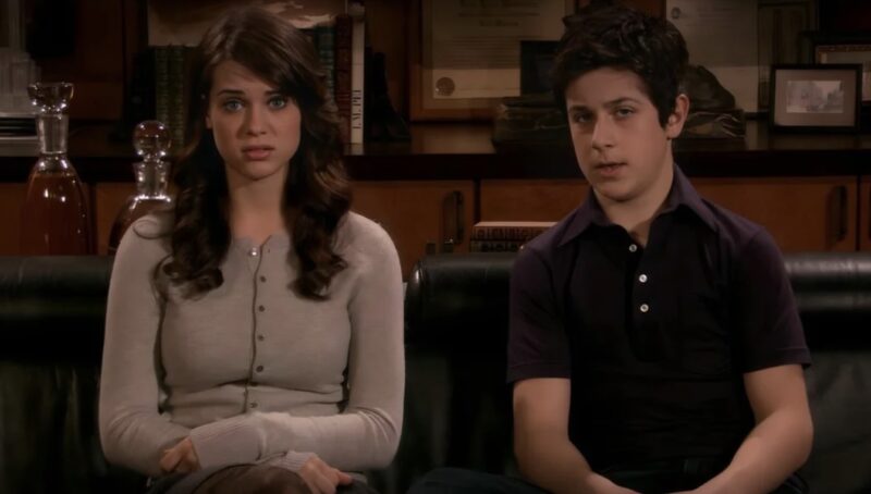 Frame de Penny Mosby, adolescente branca, olhos azuis e de cabelos escuros e ondulados, vestindo um suéter bege, e Luke Mosby, adolescente branco de cabelo castanho e usa uma camiseta polo de tom escuro, sentados lado a lado em um sofá preto de couro com uma expressão de espanto e curiosidade.